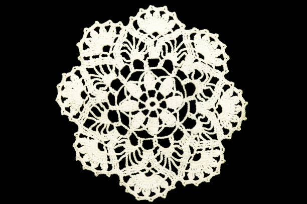 istock White hand made crocheted coaster lace doily on black background. 953948956