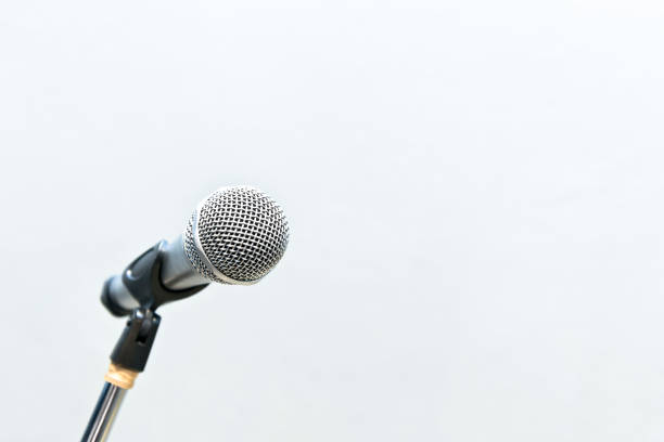 istock Metallic microphone on the stand with grey cement wall 953951446