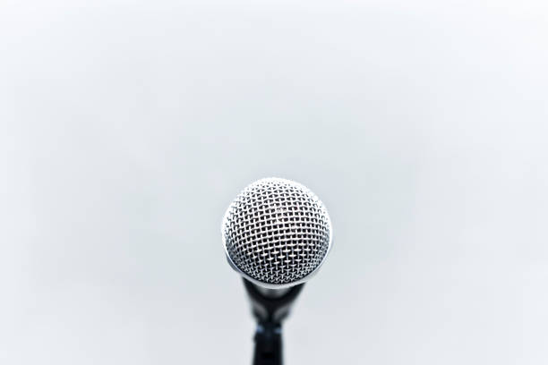 Metallic microphone on the stand with grey cement wall stock photo