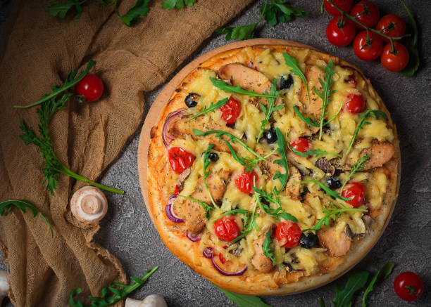 istock Pizza with chicken, arugula, cheese and onions on wooden rustic table. Top view 953962474