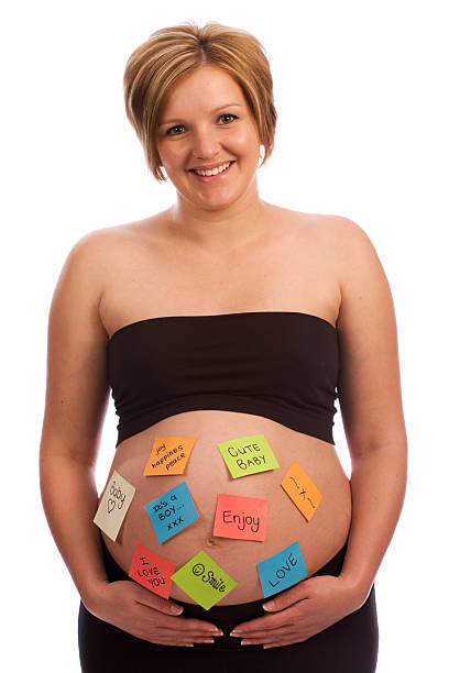 istock Attractive pregnant female with self-adhesive notes on stomach 95396636