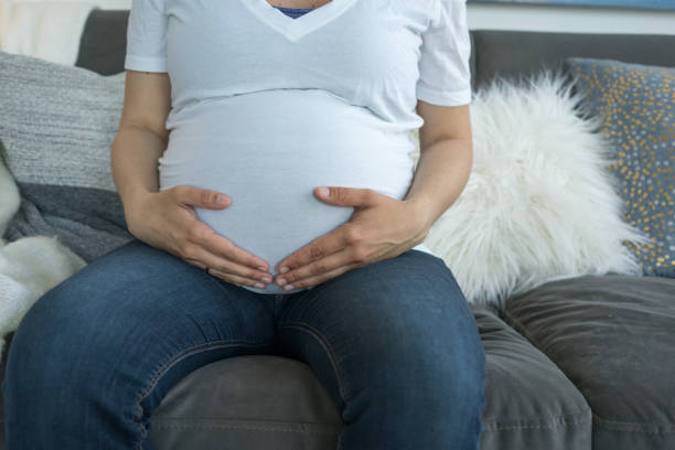 istock Pregnant woman sitting on sofa 953989860