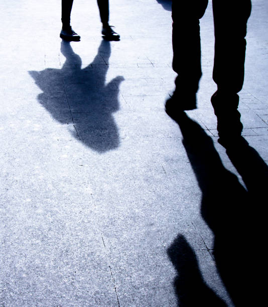 istock Silhouette shadows of two people walking alone in the night 953999338
