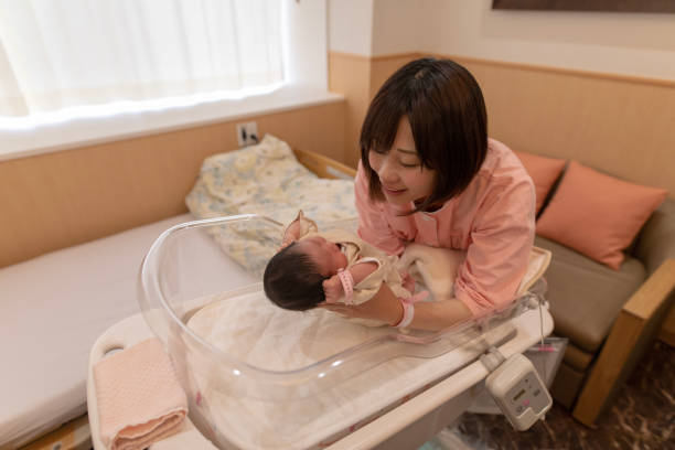 istock Mother holding up baby in crib 954006770