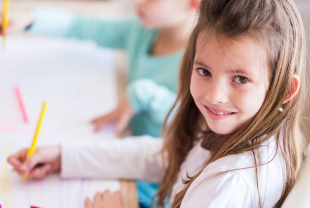 istock Smiling girl with crayons 954007374