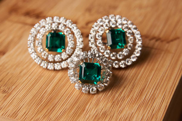 istock Emerald ring and pair of diamond earrings in gold 954008046