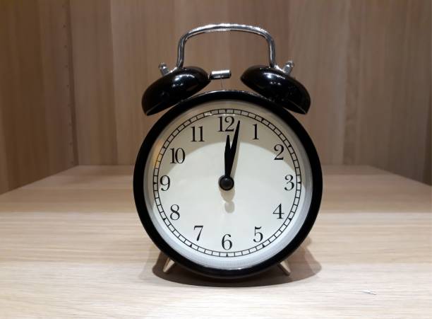 istock Retro alarm clock on wooden cabinet 954008652