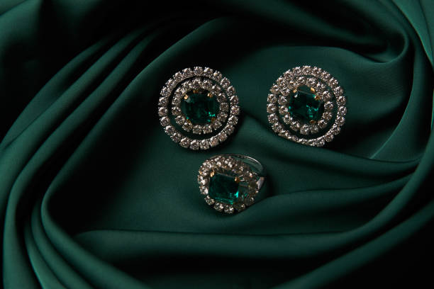 istock Emerald ring and pair of diamond earrings in gold 954008724