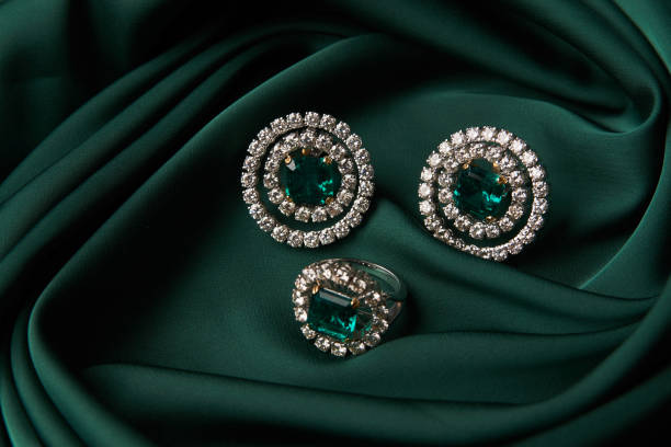 istock Emerald ring and pair of diamond earrings in gold 954008964