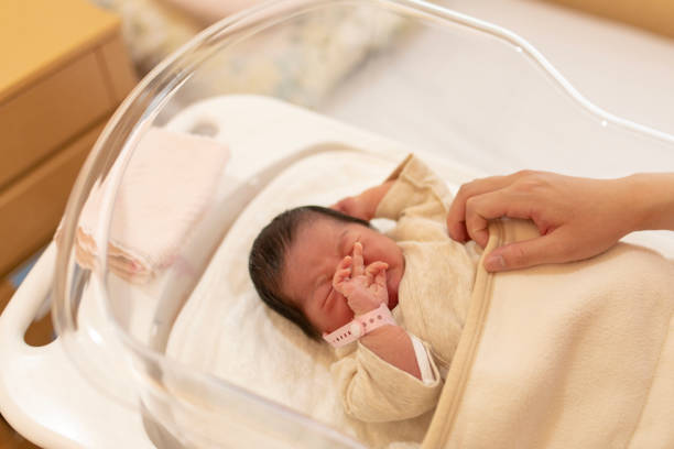 istock Mother touching baby in crib 954011798
