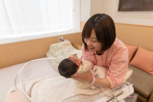 istock Mother holding up baby in crib 954011808