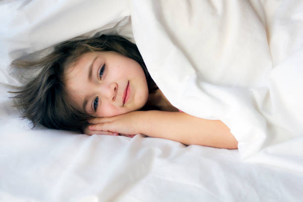 istock Smiling little girl in the bed 954012172