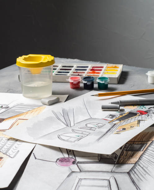 istock Creative profession: designer's desk with scattered sketches, paints, brushes, liner, pencil. 954012274