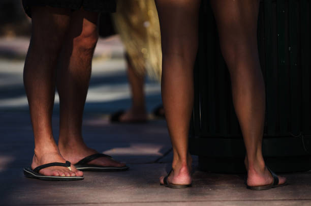 istock Young Men in Flip Flops Standing in Tropical Shadows 954016394