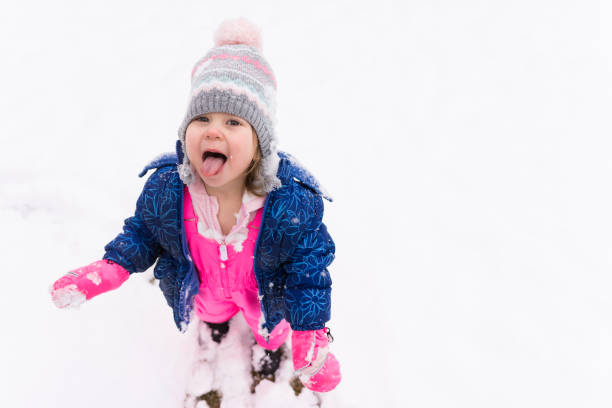 istock Cute little girl eating snow 954026394