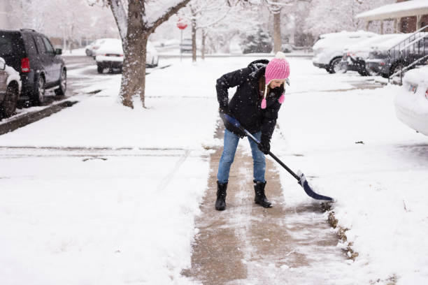 mujer joven shoveling nieve - pala fotografías e imágenes de stock