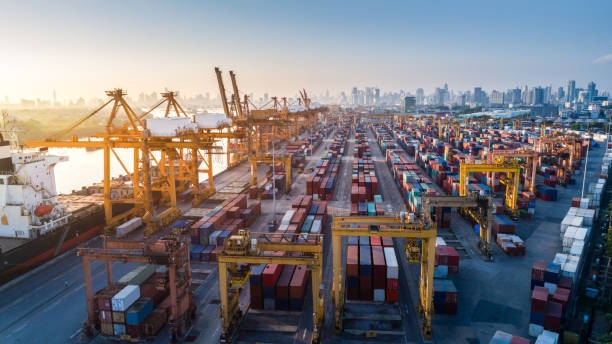 istock Logistics and transportation of Container Cargo ship and Cargo plane with working crane bridge in shipyard at sunrise, logistic import export and transport industry background 954027438