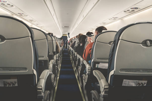 intérieur de l’avion avec des passagers sur les sièges à taik en attente au large. - airplane passenger indoors inside of photos et images de collection