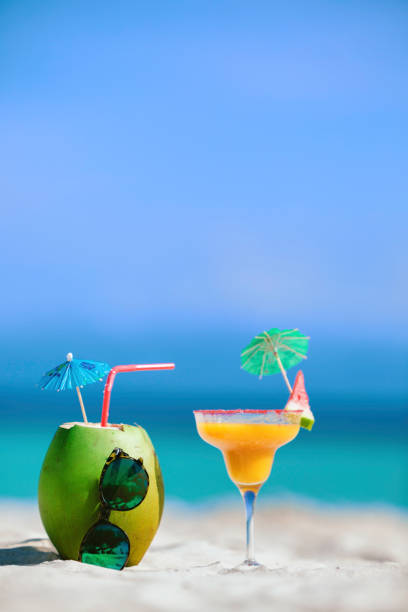 Pina Colada in a coconut tropical drink and a fruit cocktail on a Caribbean island turquoise beach