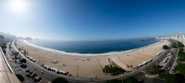 Photo of full panorama view of Copacabana beach during early morning, taken from the rooftop of a hotel, some slight fog can be seen on the blue sky. Rio de Janeiro, Brazil