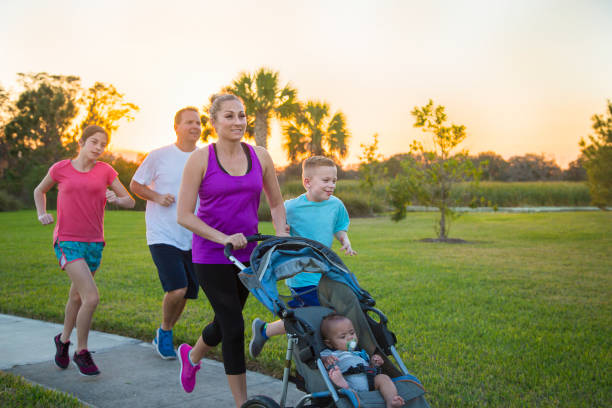 Family jogging and exercising outdoors together stock photo