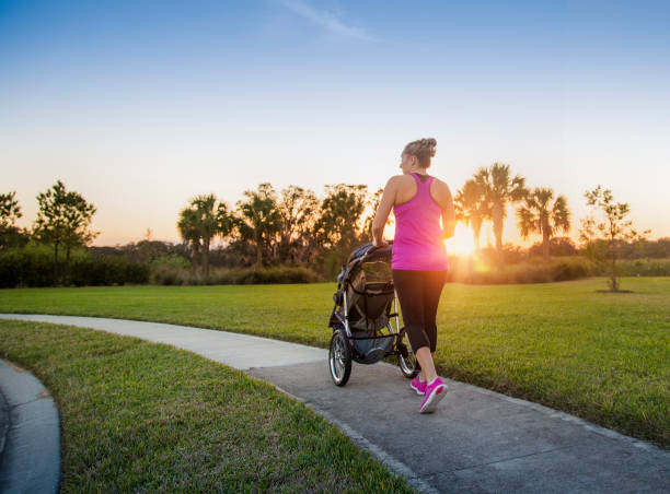 istock Woman jogging and exercising outdoors pushing her baby in a stroller 954052168