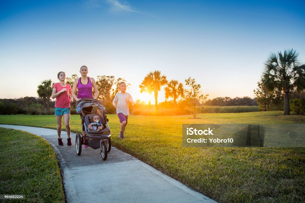 Fare jogging in famiglia ed allenarsi all'aperto insieme - Foto stock royalty-free di Famiglia