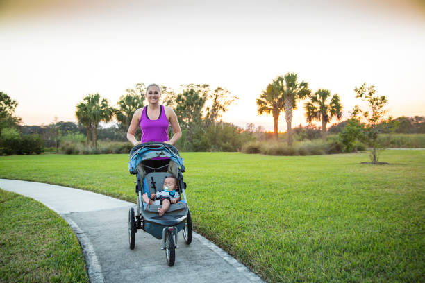 istock Woman jogging and exercising outdoors pushing her baby in a stroller 954052230
