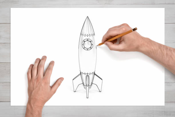 Male hands use a pencil to draw a space rocket with a round illuminator