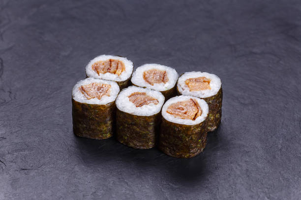 istock Fresh appetizing sushi roll with fried salmon, Japanese menu 954061274