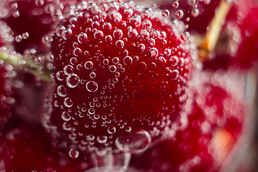 Cherries in sparkling water bubbles, close up