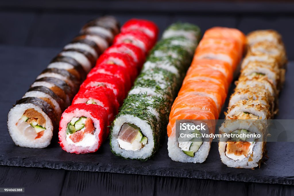 Japanese cuisine, restaurant menu photo of multicolored deliciou Japanese cuisine, restaurant menu photo of multicolored delicious set of sushi served on  black slate, close up. Art Stock Photo