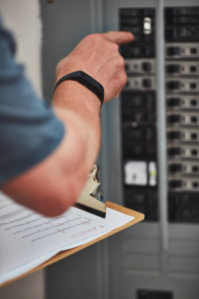 istock Male electrical engineer wearing a fitness tracker checking fuse box 954073372