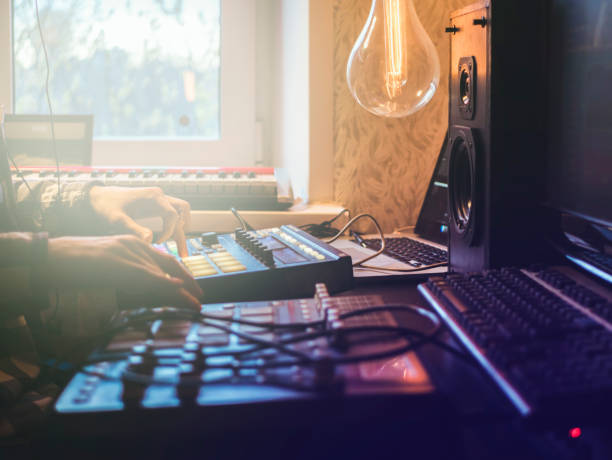 close up man making music in the home studio using drum machines