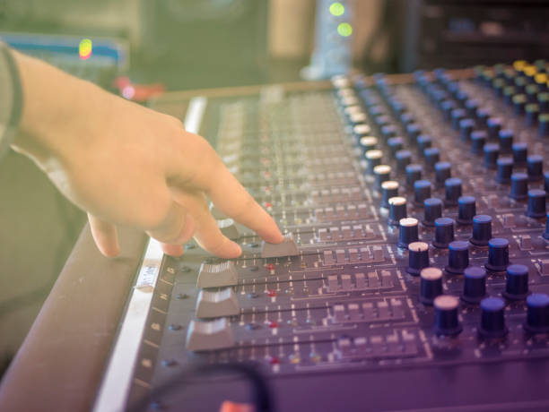 istock close up hand adjusting volume on music recording panel with faders 954074506
