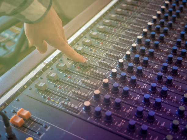 istock close up hand adjusting volume on music recording panel with faders 954074562