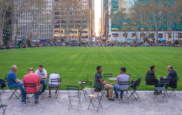 Groups of People Seating by the Bryant Park Lawn at Sunset stock photo