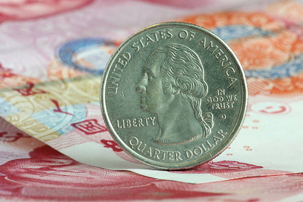istock US coin stands on Chinese paper currency. 95407488