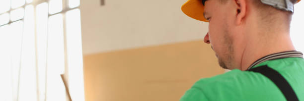istock Arms of worker making notes on clipboard with green pen 954074898