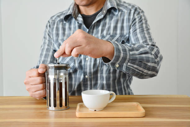 istock Man holding french press coffee pot and white cup 954077222