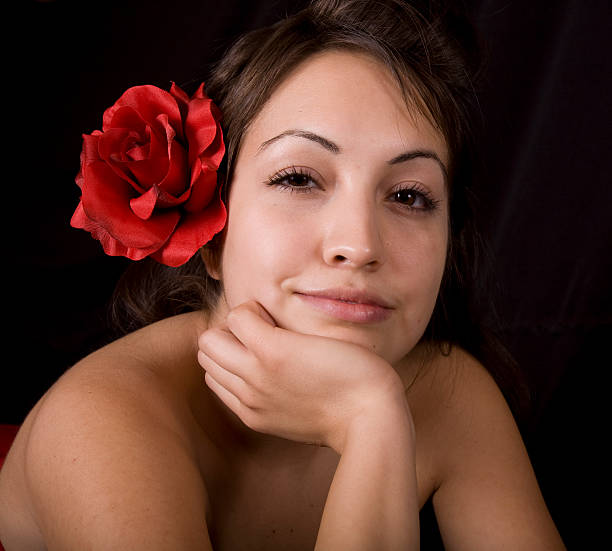 Young woman holding a red rose.