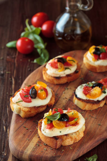 bruschetta con tomates y mozzarella. - bruschetta cutting board italy olive oil fotografías e imágenes de stock