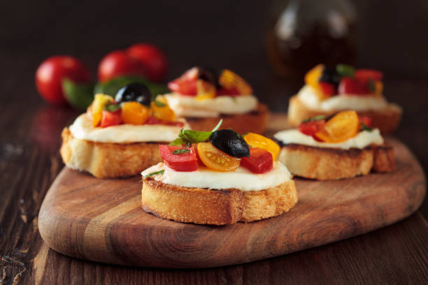 bruschetta with tomatoes and mozzarella. - bruschetta cutting board italy olive oil imagens e fotografias de stock
