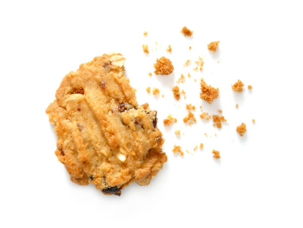 Oatmeal cookies with raisins and cashew nuts with crumbs Oatmeal cookies with raisins and cashew nuts with crumbs isolated on white background crumb stock pictures, royalty-free photos & images