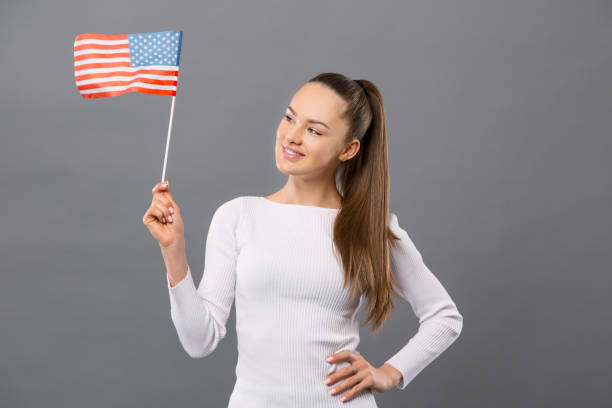 istock Pleasant young woman holding US flag 954098408