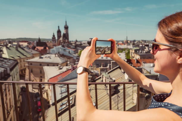 femme de touristes voyageant en europe et prendre des photos avec smartphone - krakow people poland church photos et images de collection