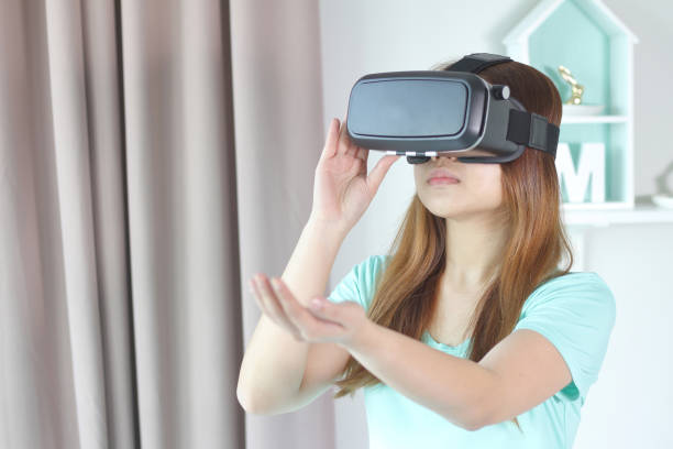 istock Young woman wearing virtual reality glasses at home. 954103122