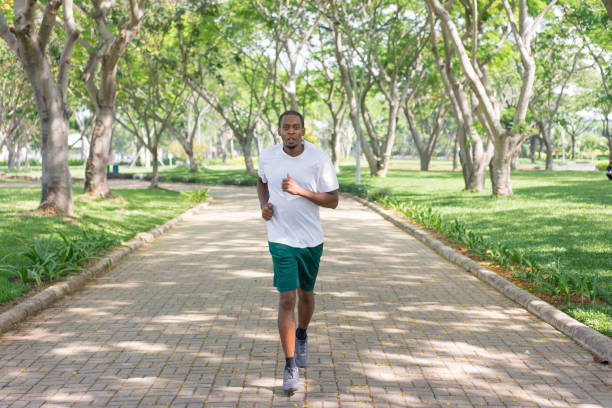 istock Focused fit black guy jogging in city park 954103494