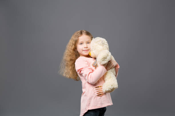 istock Delighted cute girl standing with her toy 954103530