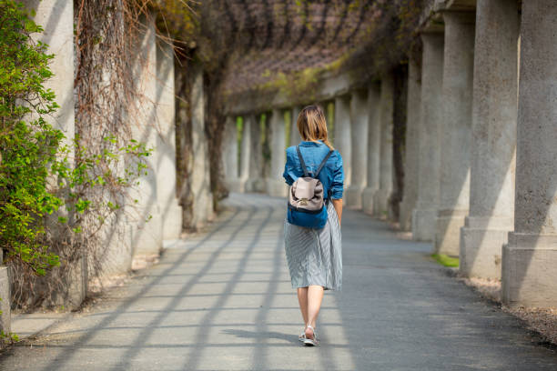 istock girl walking on alley with arches and columns 954109622
